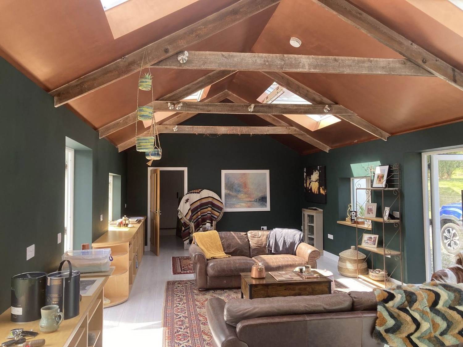 Finished sitting room — deep green walls and warm terracotta vaulted ceiling
