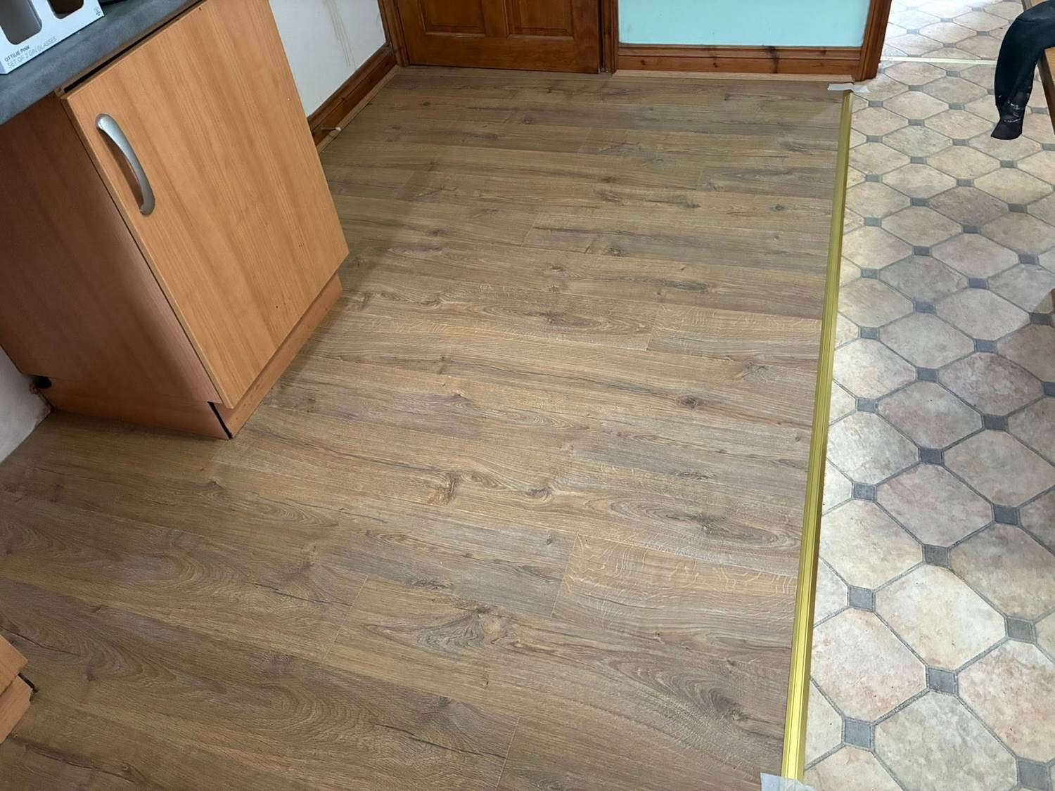 Fresh wood-effect floor fitted up to the existing kitchen tiling